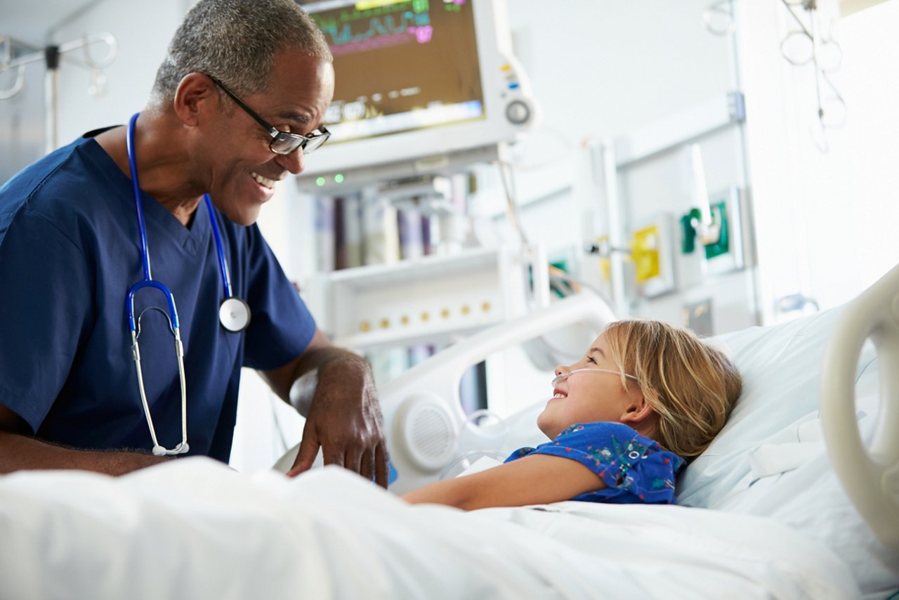 Young Girl Talking To Male Nurse In Intensive Care Unit