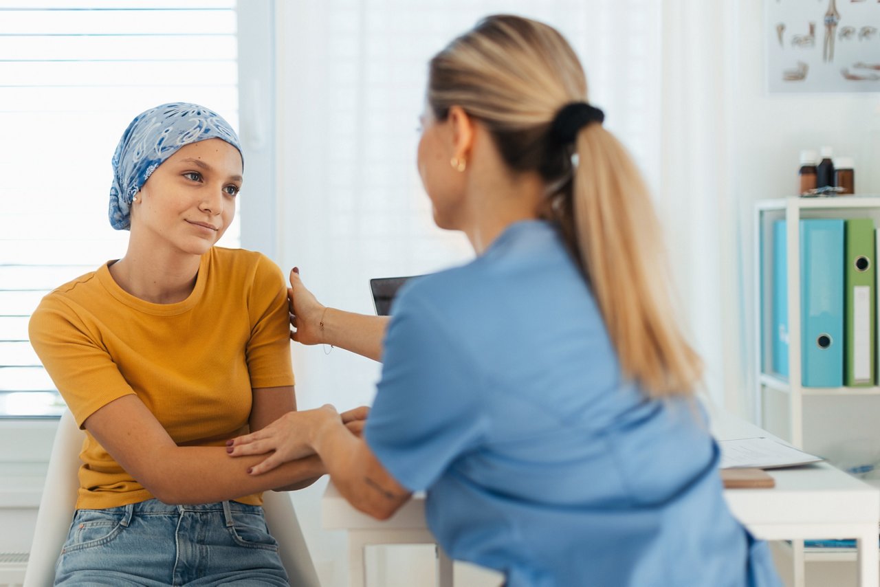 Teenage oncology patient talking with the doctor. Oncologist treating teen girl with cancer and provide emotional support, helping her with anxiety and depression.