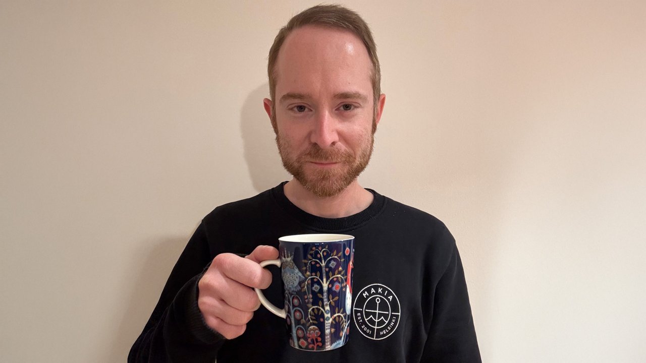 Andrea, Stability Center Coordinator at Fresenius Kabi Italia, holding a large moka cup, smiling at the camera.