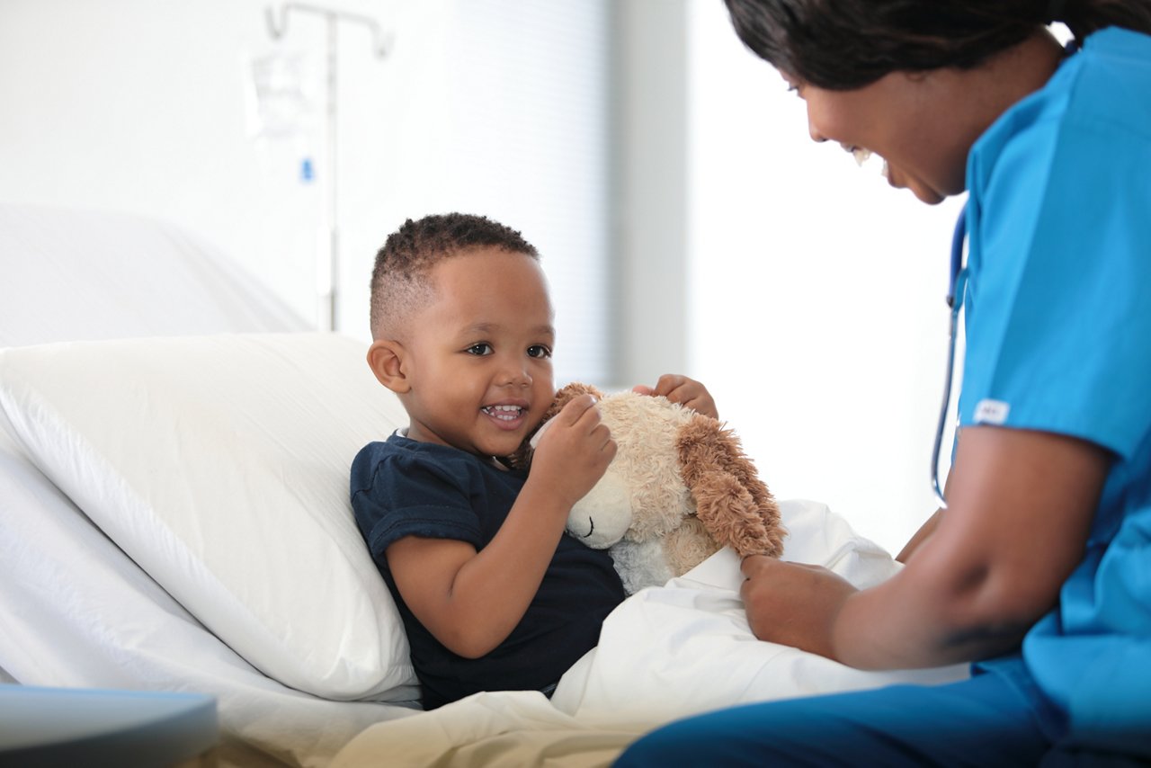 young boy with teddy and female HCP