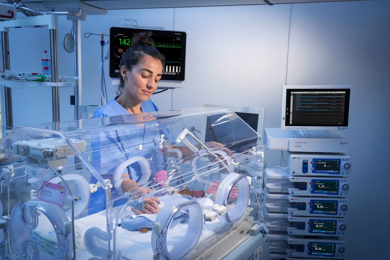 Nurse with preterm infant in an incubator