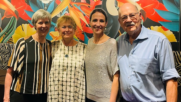 Prof. Blaauw, Prof. Berger, Lizl Veldsman, and Prof. Richard in front of a colorful mural