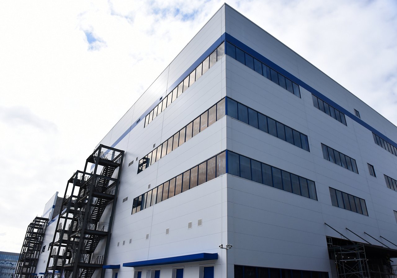Exterior view of Wuxi R&D Center building with white facade, metal staircases, and sunlit modern architecture