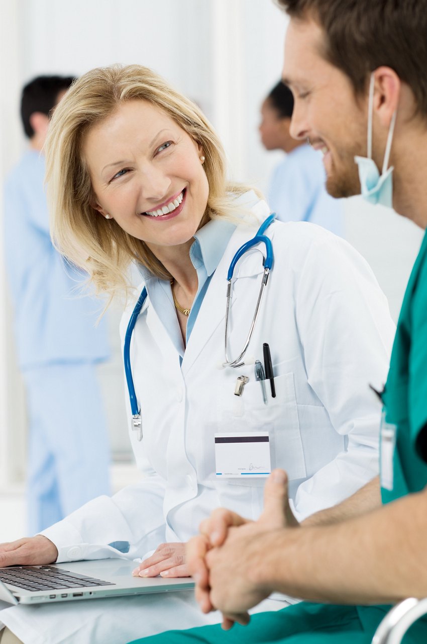 Happy Doctor In Hospital Talking With Surgeon