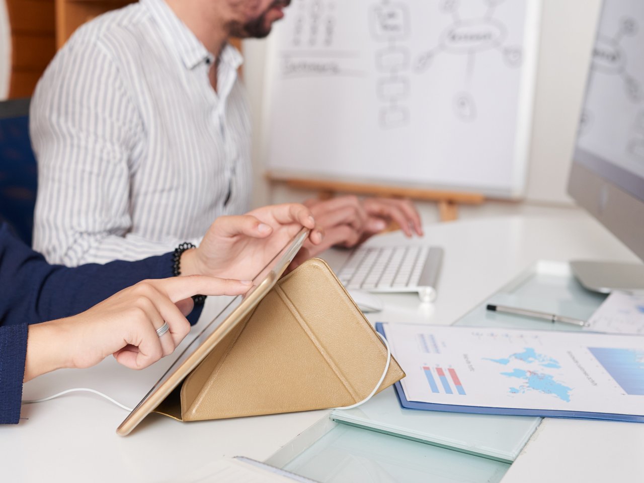 Businesswoman wearing earphones when watching presentation on tablet computer