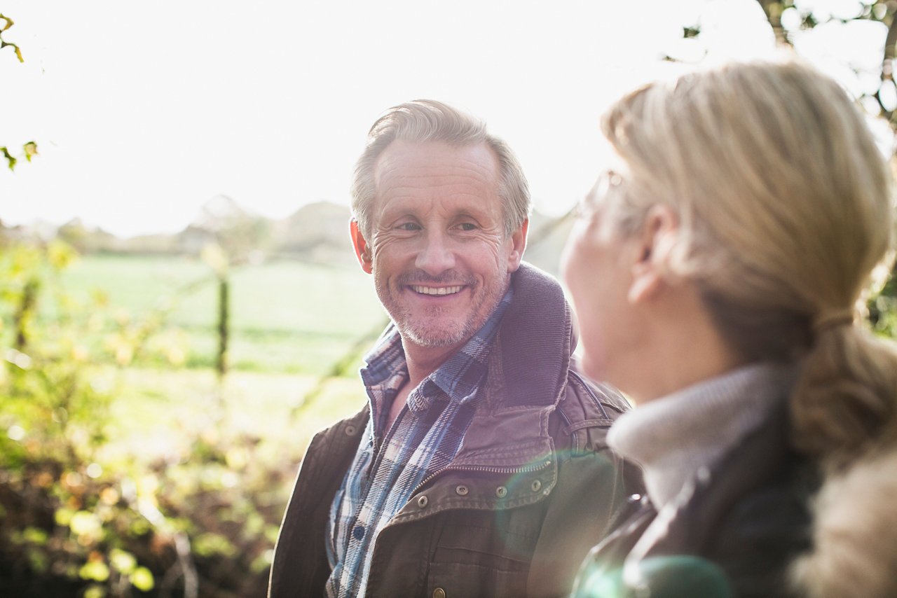 Happy senior couple in sunny autumn park