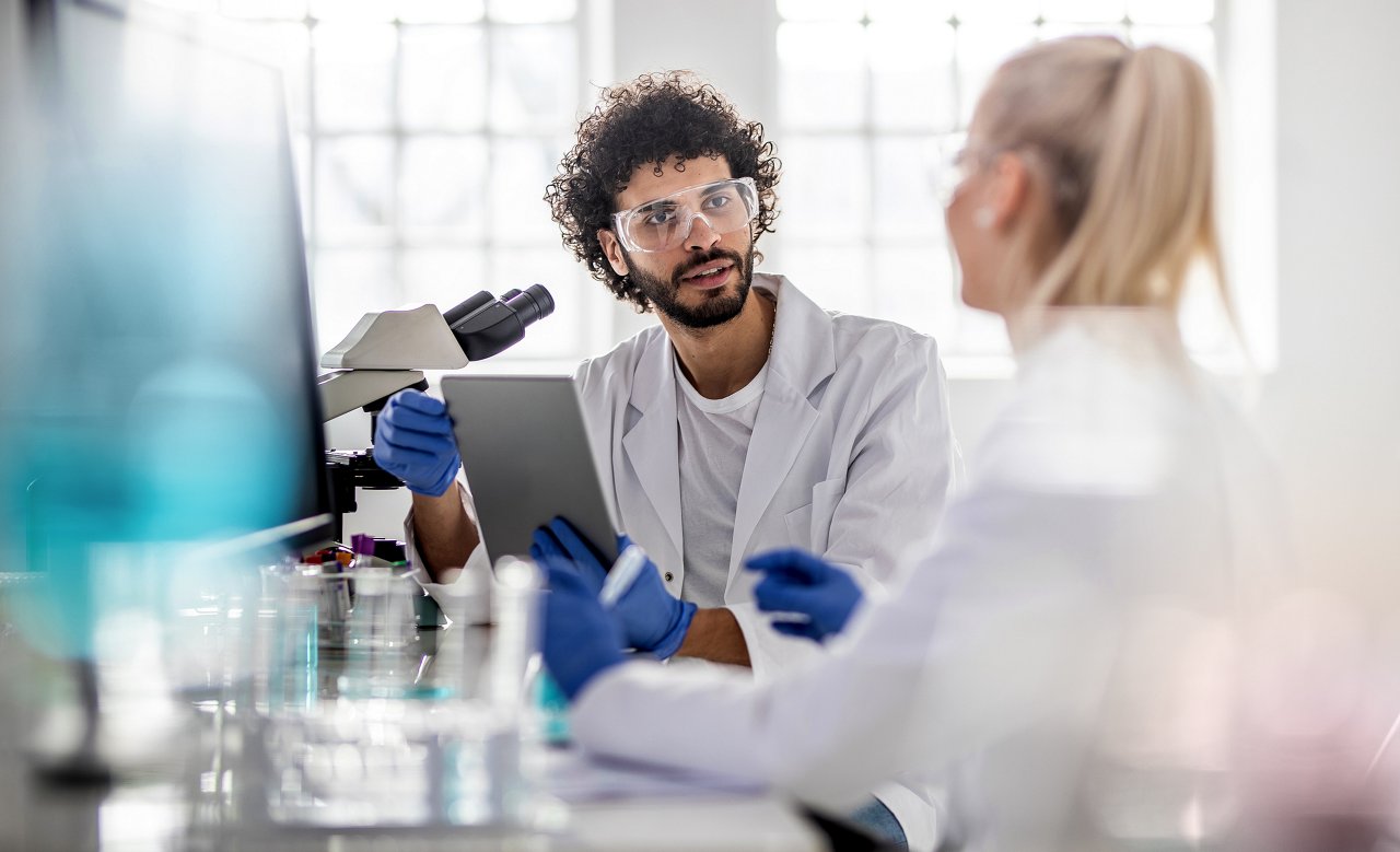 woman and man working on microscope