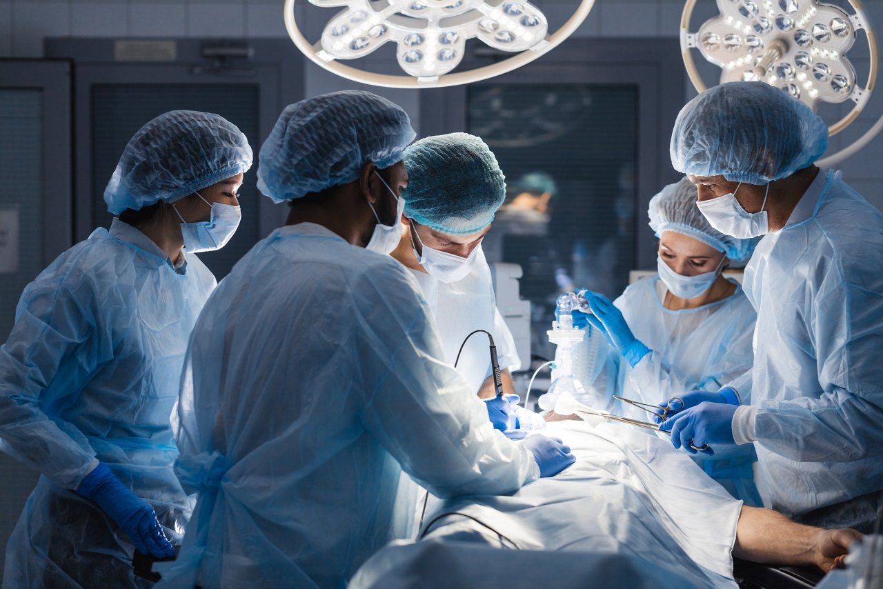Group of concentrated surgeons engaging in rescue of male patient in operation room at hospital, emergency case, surgery, medical technology, health care and disease treatment concept