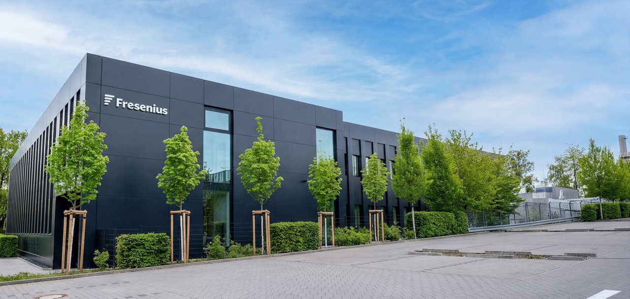 Exterior view of a modern Fresenius office or corporate building surrounded by landscaped trees.