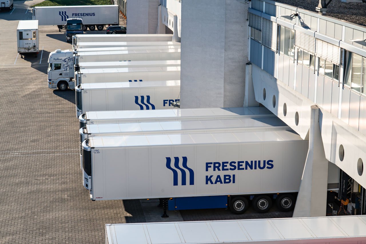 Refrigerated Fresenius Kabi trailers parked at loading docks outside a logistics and warehouse facility.