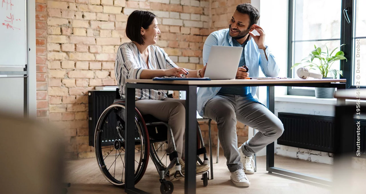 Multiracial young two colleagues smiling while working with laptop in office