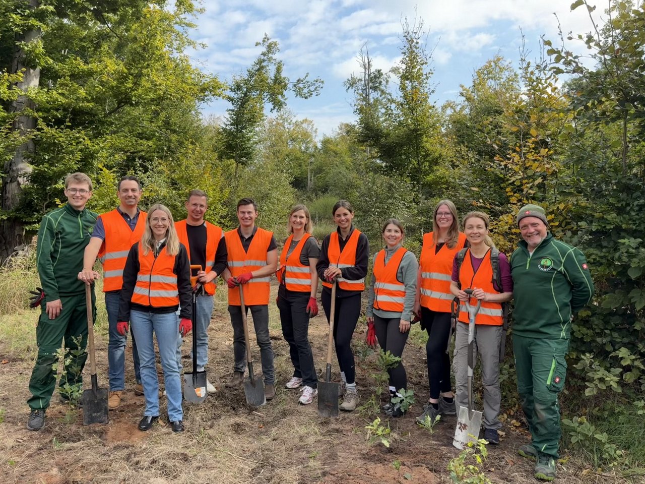 Ein Mitarbeiter arbeitet auf den Knien, während eine lachende Mitarbeiterin die Wand streicht